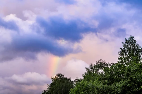 Arcobaleno dopo la pioggia in un cielo nuvoloso tra nuvole drammatiche — Foto Stock