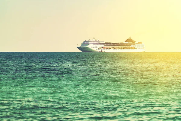 Türkisfarbenes Meer mit leichten Wellen auf dem Wasser und einem großen Kreuzfahrtschiff am Horizont — Stockfoto