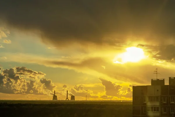 Zonnen stralen breken door de donderende wolken aan de rand van de stad — Stockfoto