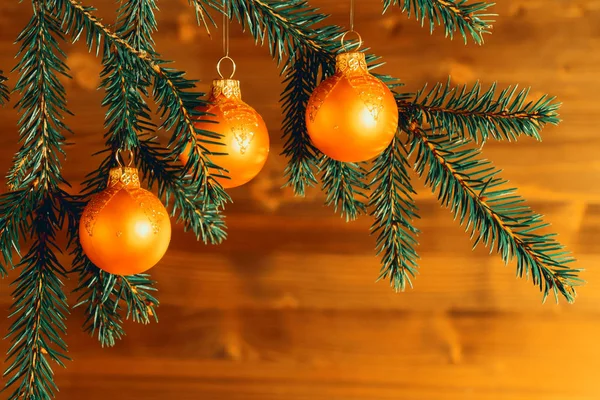 Ornements de Noël orange sur branches d'épinette sur le fond d'un mur en bois. Nouvel An ou fond de Noël — Photo