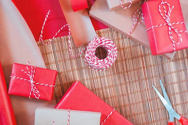 Przygotowanie do pakowania świątekowego w czerwonym i beżowym papierze do pakowania — Zdjęcie stockowe