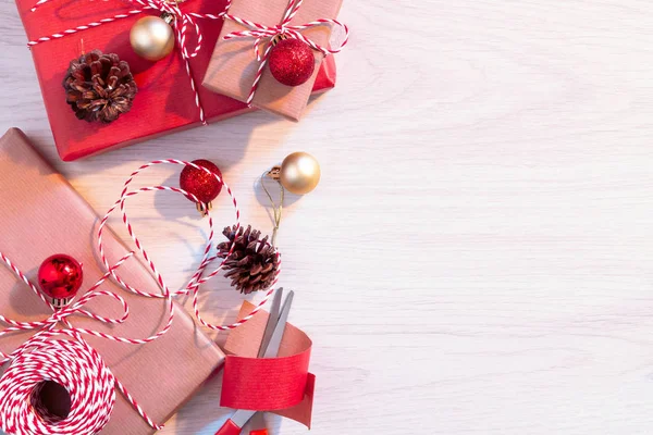 Tatil için hazırlanıyor - kırmızı ve bej ambalaj kağıdı Noel veya Noel hediyeleri sarma — Stok fotoğraf