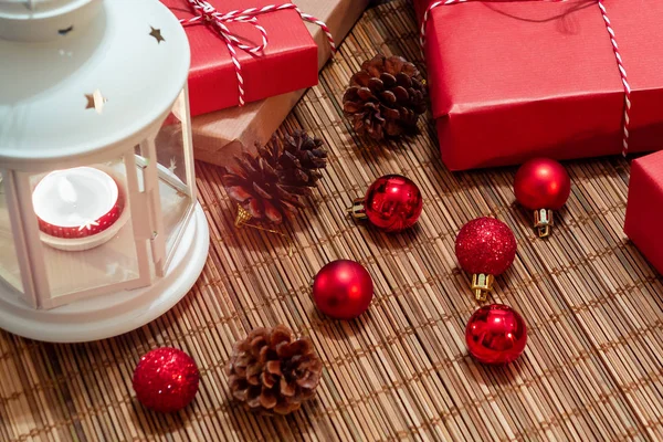 Linterna blanca con una vela encendida y cajas con regalos. Hermosa Navidad o fondo de año nuevo — Foto de Stock