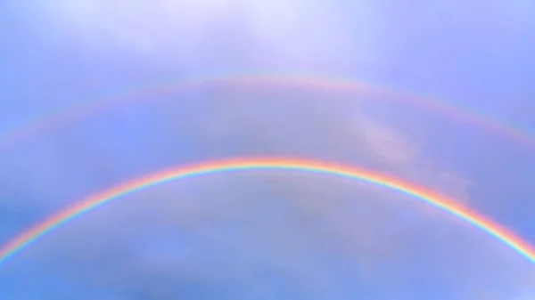 Duplo arco-íris no céu azul em um dia de verão — Fotografia de Stock