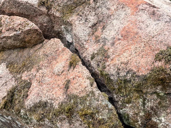 Gran roca, cubierta de musgo con una grieta — Foto de Stock