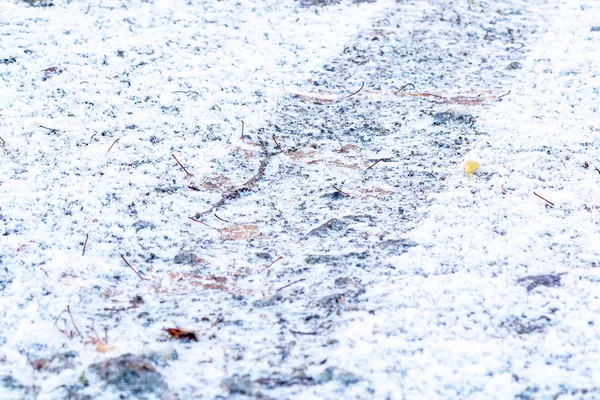 Piste d'un pneu de voiture sur un chemin de gravier après la première chute de neige — Photo