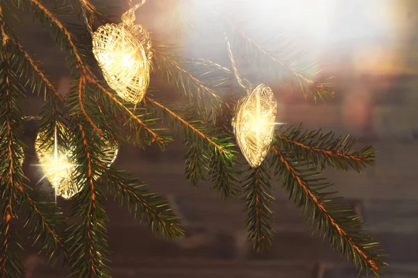Lumières de Noël sur les branches d'un arbre de Noël sur un fond de bois sombre — Photo