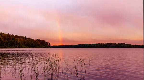Regenbogen über dem See bei Sonnenuntergang — Stockfoto