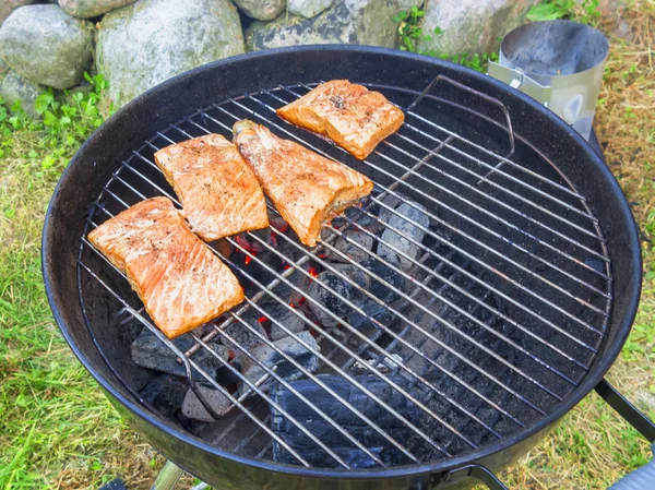 Cooking fresh salmon steaks on the grill, outdoors in summer — Stock Photo, Image