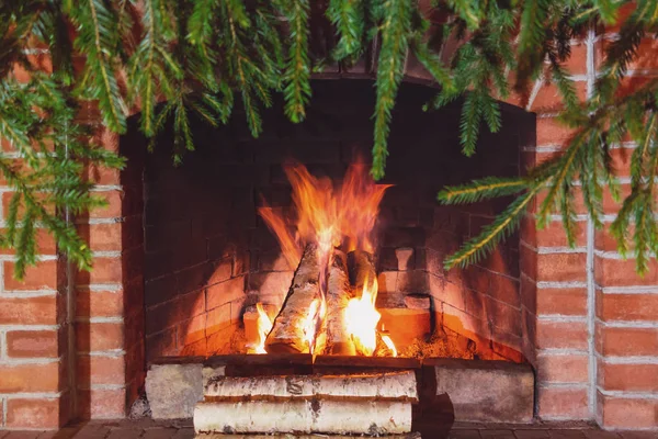 Spalanie drewna opałowego w kominku udekorowane na Boże Narodzenie z gałęzi świerk — Zdjęcie stockowe