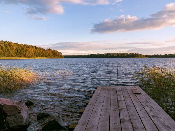 Pasarela de madera en el lago en un día de verano al atardecer —  Fotos de Stock