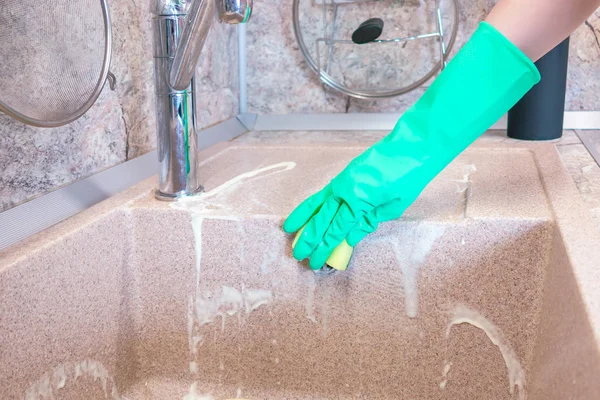 La mano di donne in un guanto pulisce un lavandino di cucina — Foto Stock