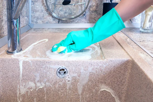 La mano di donne in un guanto pulisce un lavandino di cucina — Foto Stock