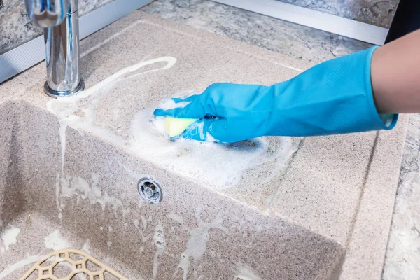 La mano di donne in un guanto pulisce un lavandino di cucina — Foto Stock