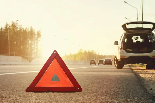 Broken car on the side of the highway and an emergency stop sign — Stock Photo, Image