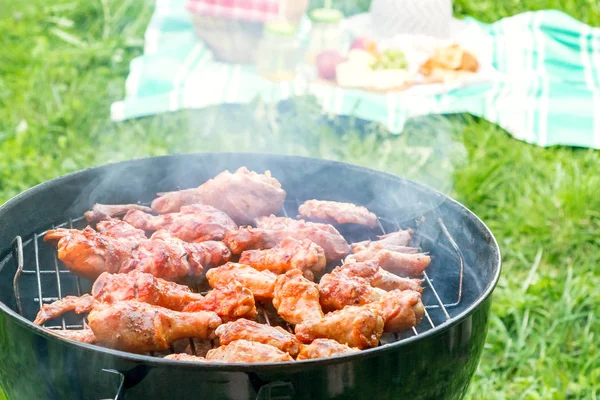 Sommerpicknick im Hof - Chicken Wings auf Rundgrill aus nächster Nähe — Stockfoto