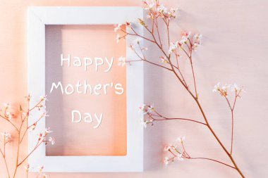 Küçük çiçekler ve yazıt Happy Mother's Day ile mercan dokulu arka plan üzerinde beyaz ahşap çerçeve - tebrik kartı