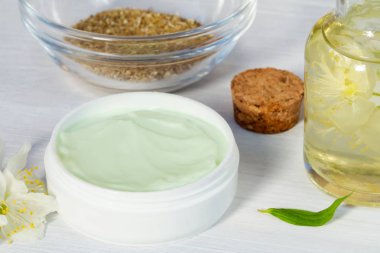 Krem kavanoz doğal bitki maddeler, yağlar ve otlar, beyaz ahşap arka plan üzerinde yasemin çiçekleri yapılan - organik kozmetik kavramı nın hazırlanması, yakın