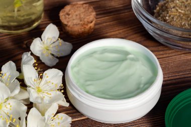 Doğal bitki maddeleri, yağlar ve otlar, koyu ahşap arka plan üzerinde yasemin çiçekleri yapılan krem Kavanoz - organik kozmetik kavramının hazırlanması, yakın