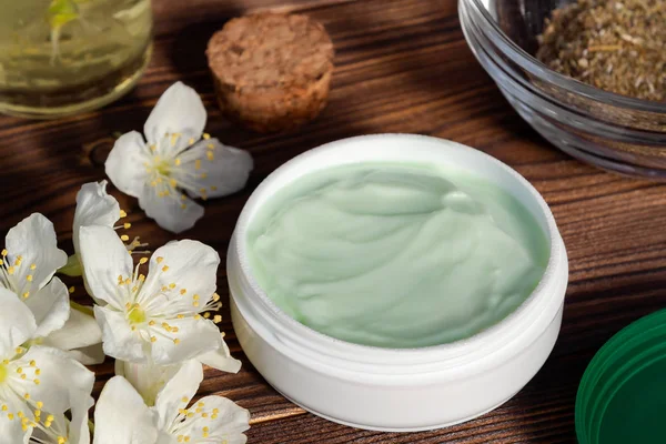 Doğal bitki maddeleri, yağlar ve otlar, koyu ahşap arka plan üzerinde yasemin çiçekleri yapılan krem Kavanoz - organik kozmetik kavramının hazırlanması, yakın