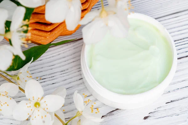 Tarro de flores de crema y jazmín sobre un fondo de madera blanca, de cerca — Foto de Stock