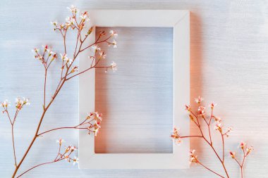 Küçük çiçeklerle beyaz dokulu arka plan üzerinde beyaz ahşap çerçeve - bir tebrik kartı veya davetiye için bir şablon