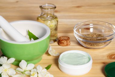 Krem kavanoz doğal bitki maddeler, yağlar ve otlar, yasemin çiçekleri, harç ve havaneli hafif ahşap arka plan yapılmış - organik kozmetik kavramının hazırlanması