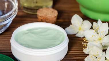 Doğal bitki maddeleri, yağlar ve otlar, koyu ahşap arka plan üzerinde yasemin çiçekleri yapılan krem Kavanoz - organik kozmetik kavramının hazırlanması, yakın