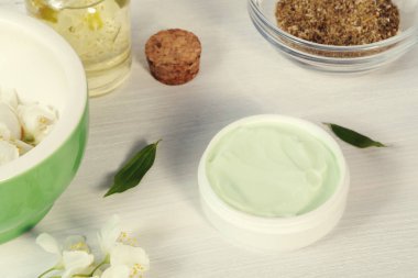 Krem kavanoz doğal bitki maddeler, yağlar ve otlar, yasemin çiçekleri, harç ve havaneli beyaz ahşap arka plan yapılmış - organik kozmetik kavramının hazırlanması