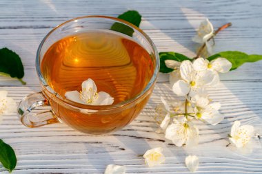 Çiçekler ve philadelphus yaprakları bir yere yasemin veya sahte portakal ve Fincan yaz aylarında beyaz bir ahşap tepsi açık havada kokulu yasemin çayı ile denilen, yakın