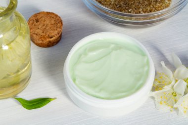 Krem kavanoz doğal bitki maddeler, yağlar ve otlar, beyaz ahşap arka plan üzerinde yasemin çiçekleri yapılan - organik kozmetik kavramı nın hazırlanması, yakın
