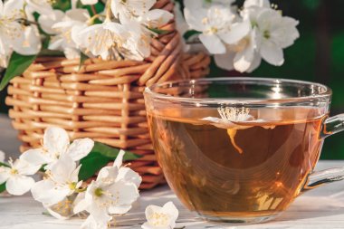 Turne içinde açık havada beyaz ahşap tepsi üzerinde kokulu Yasemin çayı ile Yasemin veya sahte turuncu ve fincan denilen bir yerde Philadelphia çiçekler ile sepet