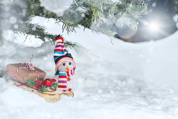 Composição de Natal abaixo da árvore de Natal - um boneco de neve, caixas com presentes em um trenó, lugar do texto, espaço de cópia — Fotografia de Stock