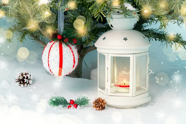 Kerst samenstelling-een lantaarn met een brandende kaars en decoraties onder de kerstboom — Stockfoto