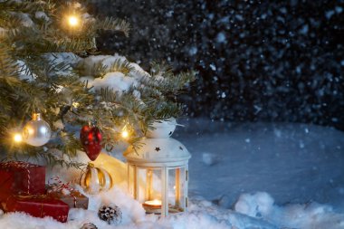Noel kompozisyon - hediyeler ve ışıklar ve Noel ağacı süslemeleri ile süslenmiş bir Noel ağacı altında karda bir fener, kopya alanı, metin için yer