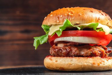 Köfteli, domatesli, marullu, peynirli ve soğanlı taze ev yapımı burger.