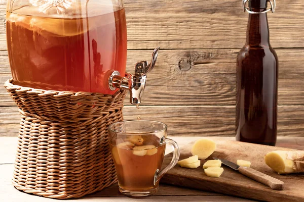 Φρέσκο σπιτικό Κοπούτσα που έχει υποστεί ζύμωση τσάι σε βάζο με βρύση και σε φλιτζάνι και μπουκάλι σε ξύλινο φόντο — Φωτογραφία Αρχείου