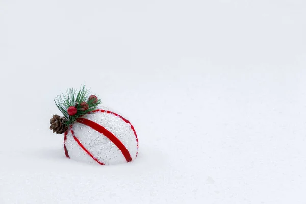 Bola vermelha e branca em uma árvore de Natal nevada — Fotografia de Stock