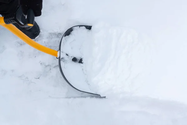 Un uomo pulisce la neve nel cortile con una pala dopo una forte nevicata — Foto Stock