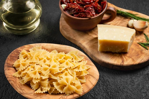 Maak pasta klaar met zongedroogde tomaten en parmezaanse kaas. Italiaanse keuken, ingrediënten — Stockfoto