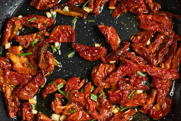 Tomates secos fritos con ajo y romero para hacer salsa de pasta. Etapas de la cocina italiana — Foto de Stock