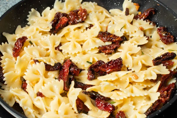 Pastas fritas con tomates secados al sol y ajo. Etapas de la cocina italiana — Foto de Stock