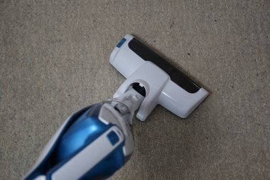 Yerde bir elektrik süpürgesi var.