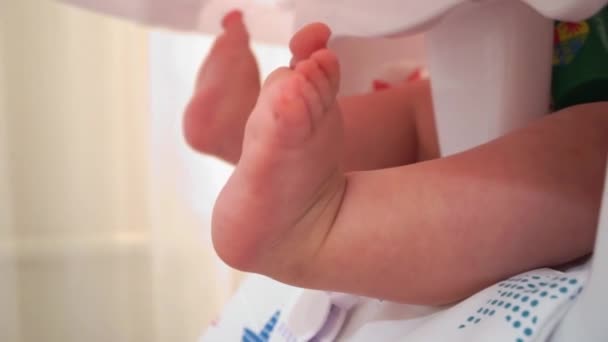 Pequeño Bebé Jugando Con Las Piernas Silla — Vídeos de Stock