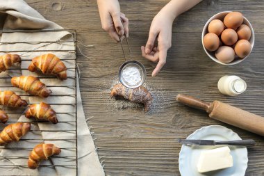 Pasta şefi taze bir el tepesi pudra şekeri ile kruvasan yaptı