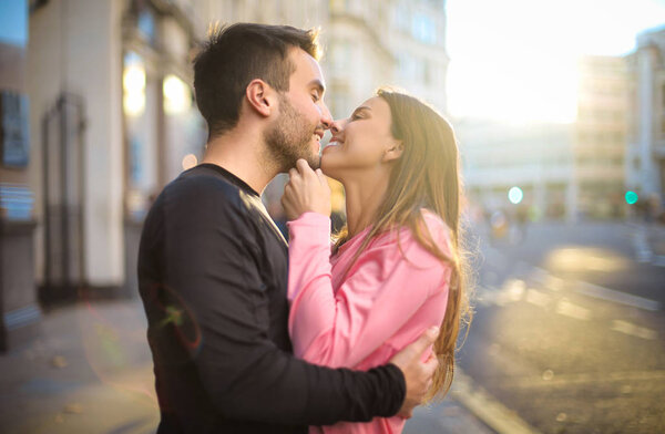 Романтическая пара нежно целуется на улице

