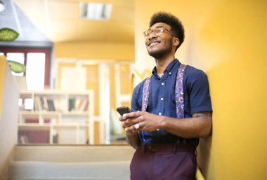 Hnadsome adam onun akıllı telefon chiecking sırasında gülümseyen