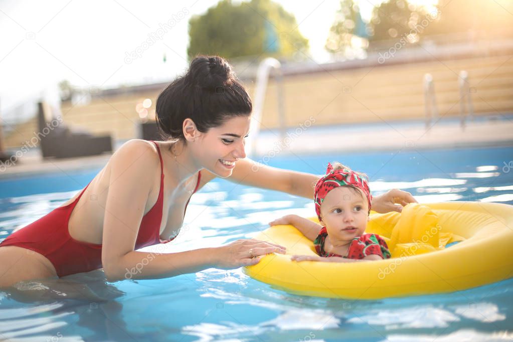 Sweet mom enjoying time with her baby in the swimming pool