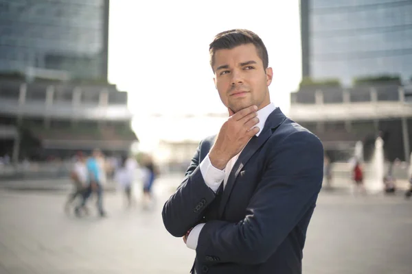 Handsome young businessman looking at the distance thoughtfully