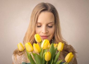 Çiçek buketi tutan güzel genç bir kadın.